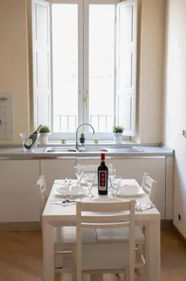 a table with a white table cloth with plates and silverware at Pandy Suite in Rome