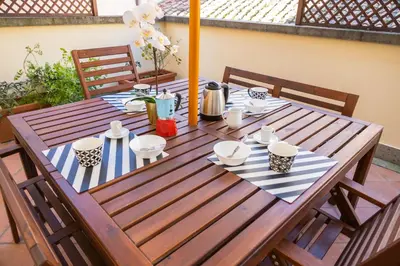 a table and chairs with an umbrella on a patio at Pandy Suite in Rome