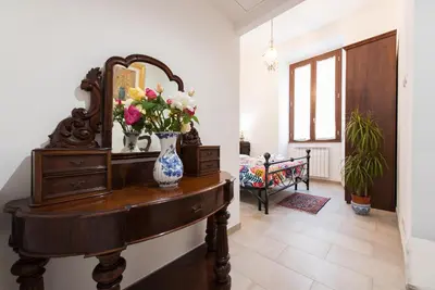 a room with a mirror and a table with flowers on it at Circus Maximus n 1-at 400m Metro in Rome