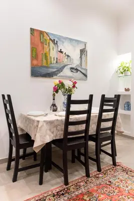 a dining room table with chairs and a vase of flowers at Circus Maximus n 1-at 400m Metro in Rome