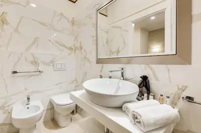 a white bathroom with a sink and a toilet at Trevi Chic House in Rome
