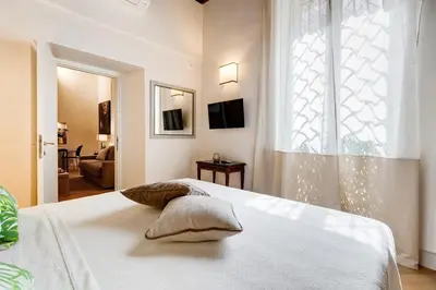 a bedroom with a white bed with a window at Trevi Chic House in Rome