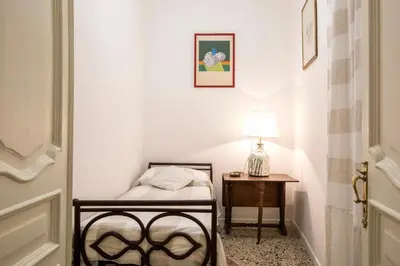 a small bedroom with a bed and a table at Flat Six in Rome