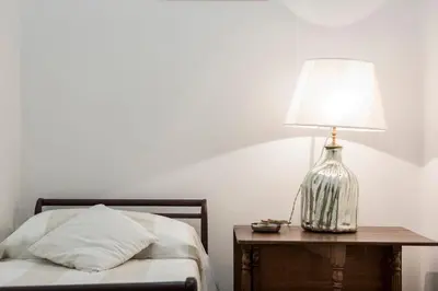 a lamp on a table next to a bed at Flat Six in Rome