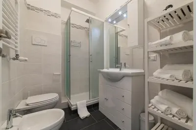 a bathroom with a toilet and a sink and a shower at Nomentana White Apartments in Rome