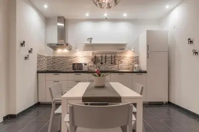 a kitchen with a table and chairs and a refrigerator at Nomentana White Apartments in Rome