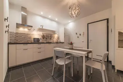 a kitchen with white cabinets and a table and chairs at Nomentana White Apartments in Rome