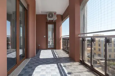 a hallway in a building with large windows and a clock at Nomentana White Apartments in Rome