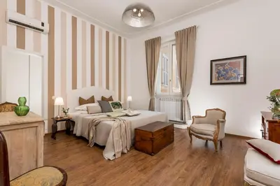 a white bedroom with a bed and a chair at New! Spanish Step Design Apartment in Rome