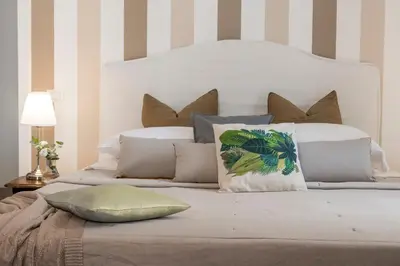 a bed with a white headboard and pillows on it at New! Spanish Step Design Apartment in Rome