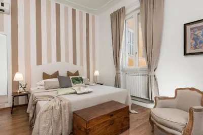 a white bedroom with a bed and a chair at New! Spanish Step Design Apartment in Rome