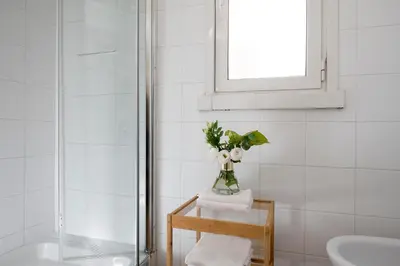 a bathroom with a vase of flowers on a table at Grotte Apartment near Campo dé Fiori in Rome
