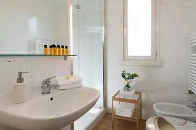 a white bathroom with a sink and a mirror at Grotte Apartment near Campo dé Fiori in Rome