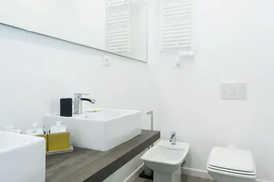 a white bathroom with a sink and a toilet at Casa Bella Pantheon in Rome