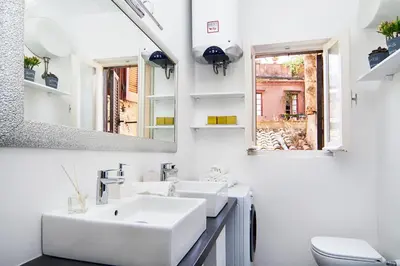 a white bathroom with two sinks and a mirror at Casa Bella Pantheon in Rome