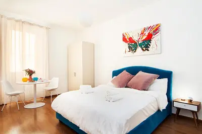 a bedroom with a blue and white bed and a table at Casa Bella Pantheon in Rome