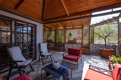 a screened in porch with chairs and a table at Amazing Penthouse with Terrace by Caracalla in Rome