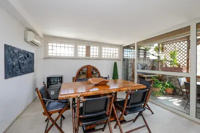 a dining room with a wooden table and chairs at Amazing Penthouse with Terrace by Caracalla in Rome