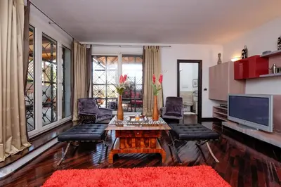 a living room with a table and chairs and a television at Amazing Penthouse with Terrace by Caracalla in Rome