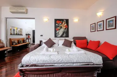 a bedroom with a large bed and a couch at Amazing Penthouse with Terrace by Caracalla in Rome