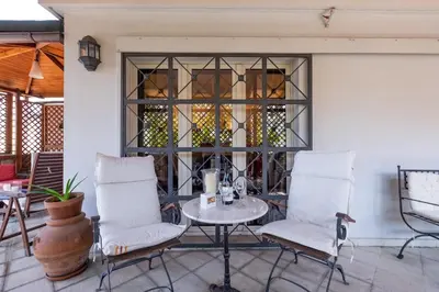 a patio with two chairs and a table and a window at Amazing Penthouse with Terrace by Caracalla in Rome