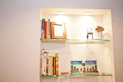 a book shelf with books and a picture on it at The heart of Trastevere in Rome