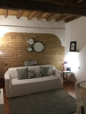 a living room with a couch and a brick wall at The heart of Trastevere in Rome