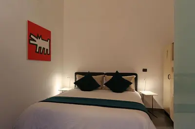 a bedroom with a white bed with black pillows at Mr Frills in Rome