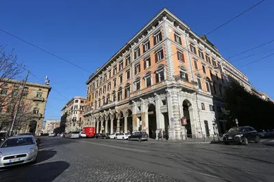 a large brick building on a city street with cars parked at Mr Frills in Rome