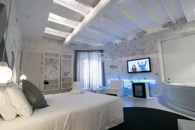 a bedroom with a white bed and a tv on the wall at Design&Art Pie' - Elegant Rooms Near the Pantheon, Calm & Central Stay in Rome