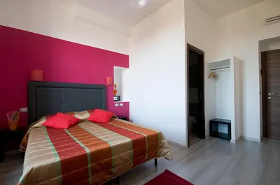 a bedroom with a large bed with a red wall at MF Hotel in Rome