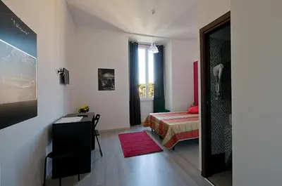 a bedroom with a bed and a desk and a room at MF Hotel in Rome