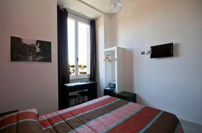 a bedroom with a bed and a window and a desk at MF Hotel in Rome