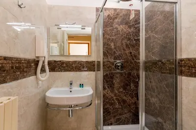 a bathroom with a sink and a shower at Hearth Hotel in Rome