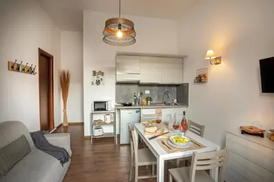 a kitchen and a living room with a table in a room at Fornaci Vatican Flat in Rome