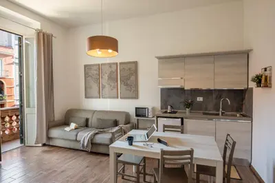 a kitchen and living room with a table and a couch at Fornaci Vatican Flat in Rome