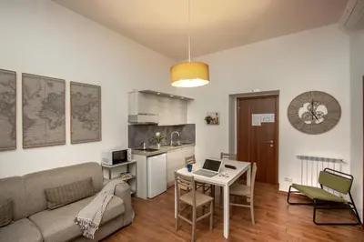 a living room with a couch and a table with a laptop at Fornaci Vatican Flat in Rome