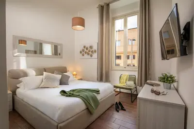 a bedroom with a white bed and a window at Fornaci Vatican Flat in Rome