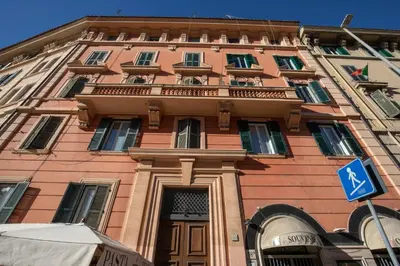 a tall pink building with a sign in front of it at Fornaci Vatican Flat in Rome