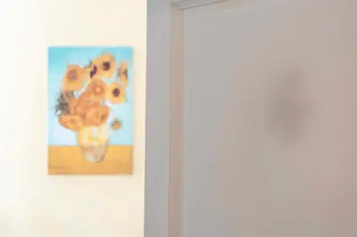 a painting of a flower on a wall next to a door at St. Peter Central Rooms B&B in Rome