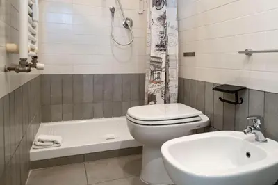 a bathroom with a toilet and a sink and a tub at St. Peter Central Rooms B&B in Rome