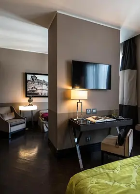 a hotel room with a bed and a desk with a lamp at Rome Times Hotel in Rome