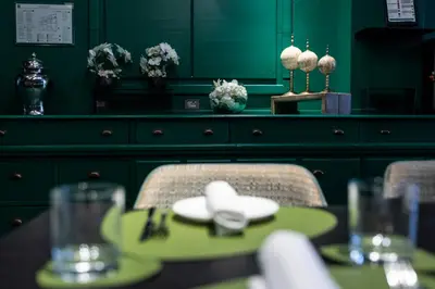 a green dining room with a table and chairs at Rome Times Hotel in Rome