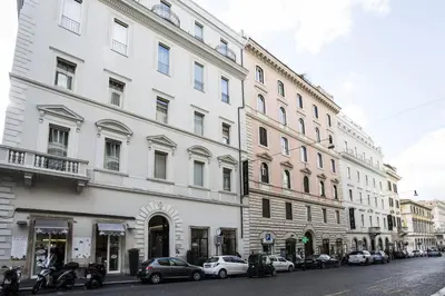 a large white building with cars parked on a street at Rome Times Hotel in Rome