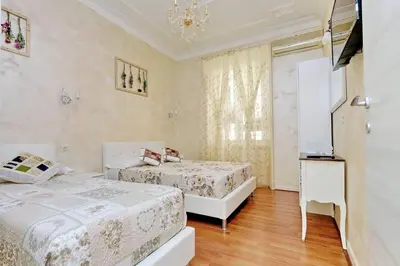 a bedroom with two beds and a chandelier at AL Holiday Home in Rome