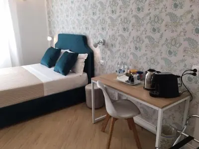 a small bedroom with a bed and a table with a chair at Affreschi a San Pietro in Rome