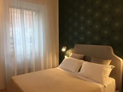 a bedroom with a bed with white sheets and a window at Affreschi a San Pietro in Rome