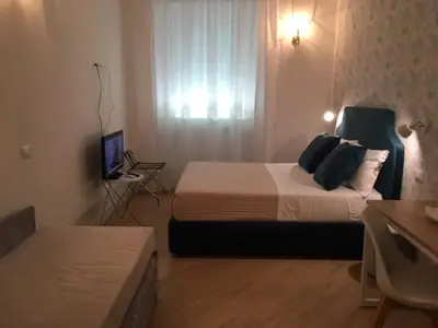 a hotel room with two beds and a television at Affreschi a San Pietro in Rome