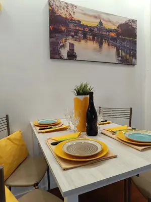 a table with yellow napkins and plates on it at Casa Vacanze Mafalda - Roma Stazione Trastevere in Rome