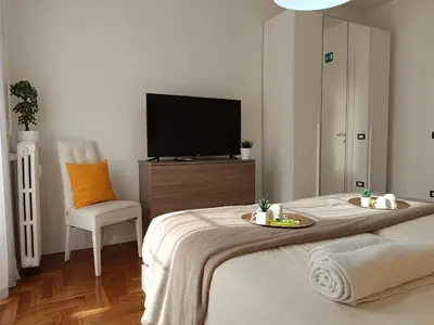a bedroom with a bed with a tv and a chair at Casa Vacanze Mafalda - Roma Stazione Trastevere in Rome